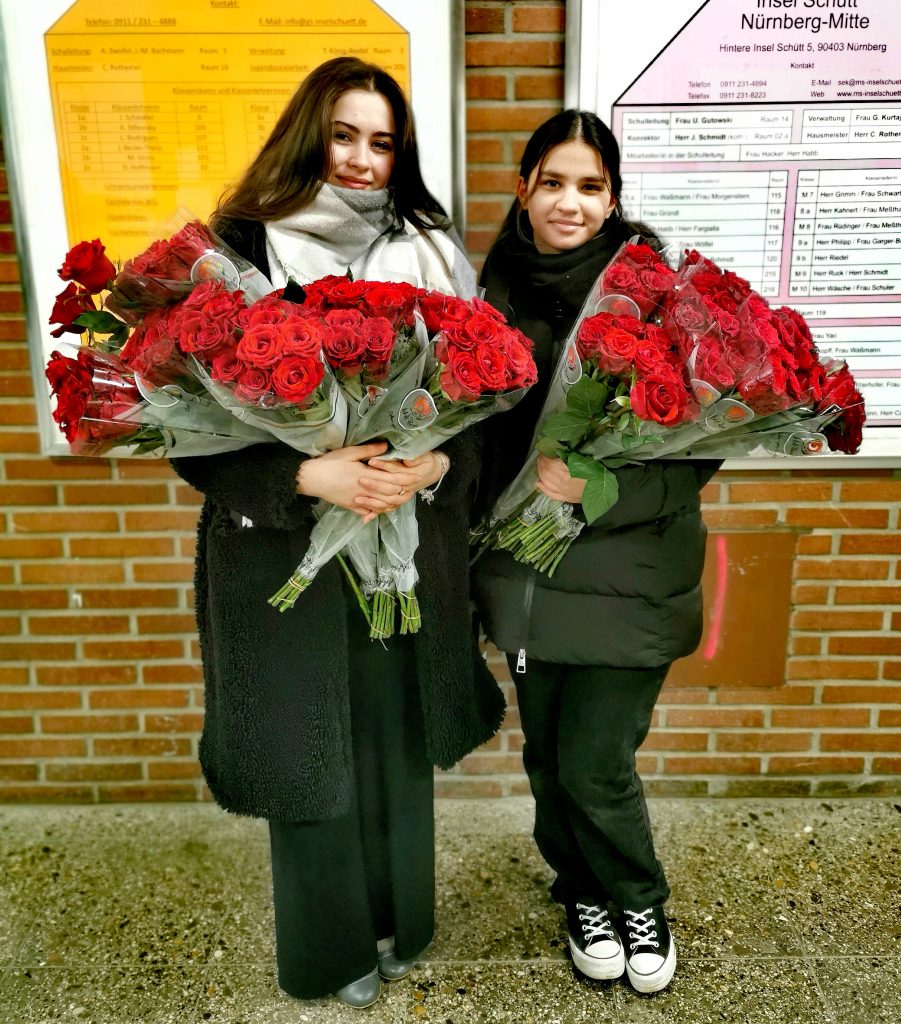 Zwei Schüler mit 160 Rosen im Arm.