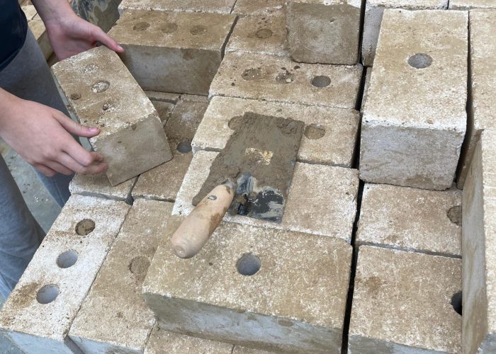 Eine Mauer wird mit Steinen errichtet.